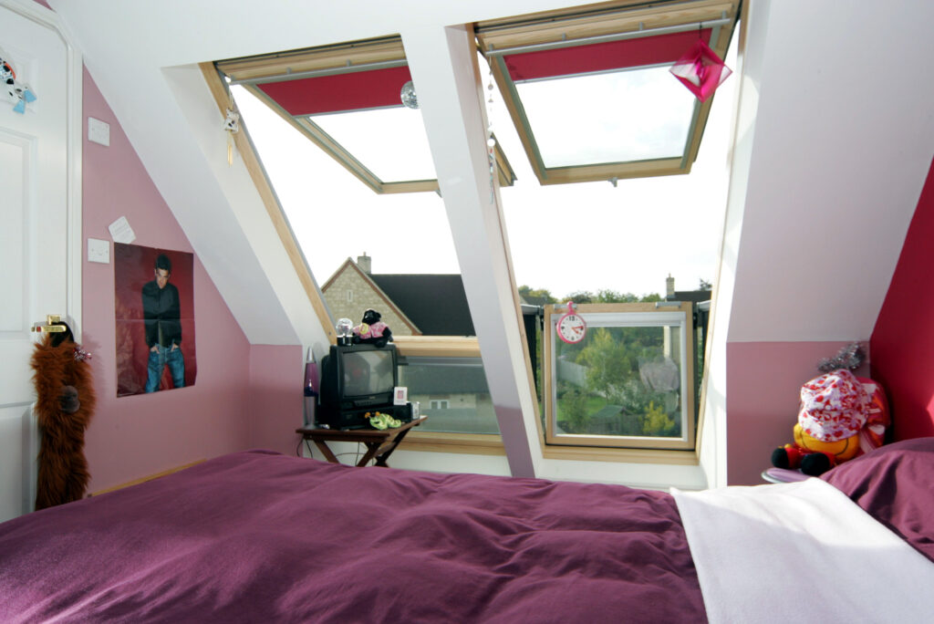 A new bedroom in a loft conversion with floor to ceiling VELUX windows