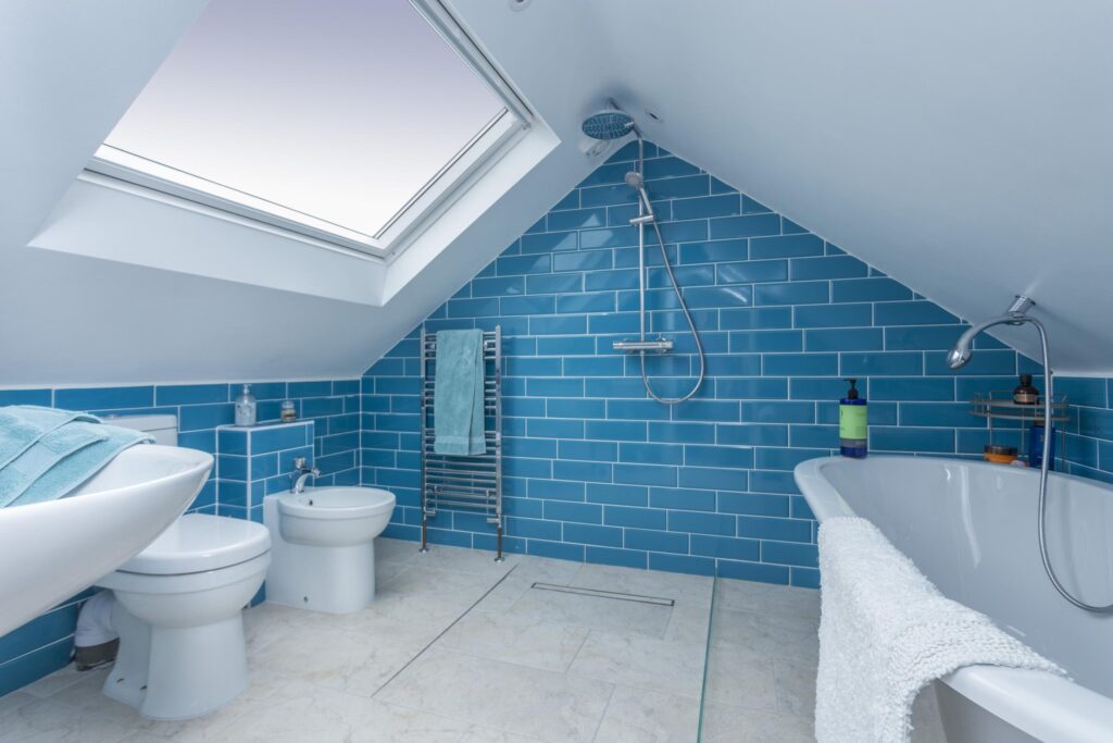 Blue tiled ensuite bathroom with VELUX window and feature shower