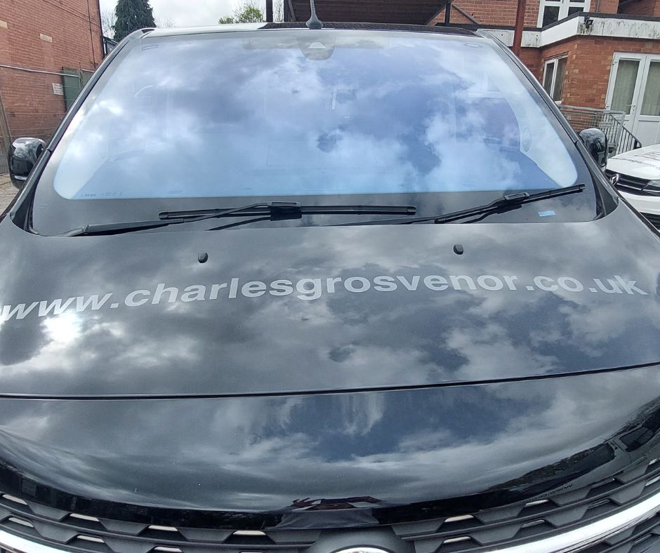 Closeup on a van bonnet printed with the Charles Grosvenor website address