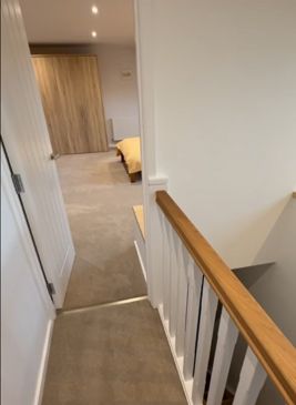 A new staircase bannister on a landing leading through to a bedroom suite