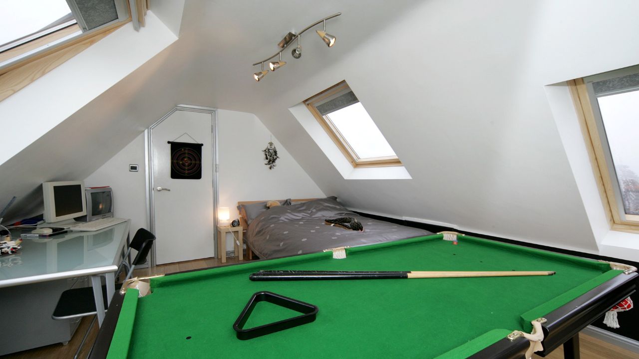 Loft conversion with three VELUX windows with a work desk, double bed and pool table