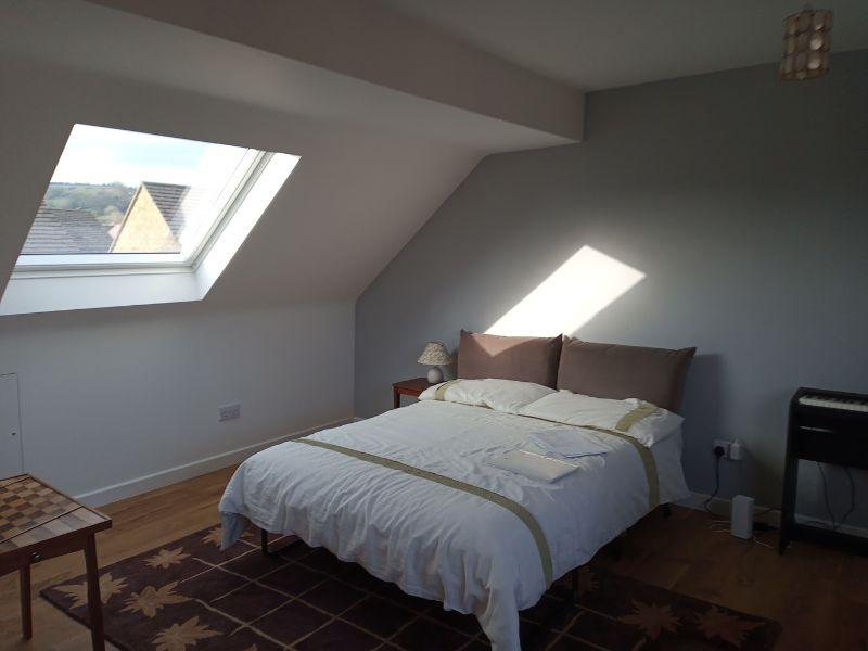 A double bedroom with light coming through a VELUX window